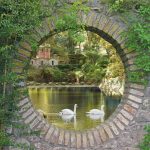 tuinposter stenen doorkijk zwanen